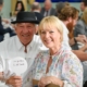 A man and a woman smile as they sit at a table.