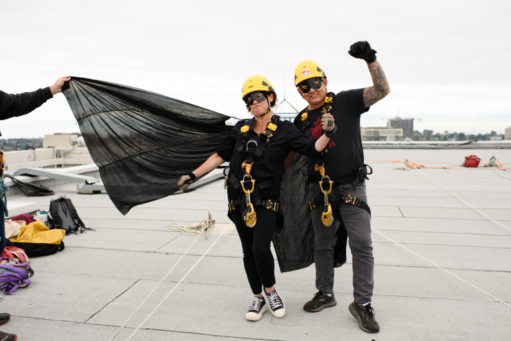 Two drop zone rappellers dressed in all black with capes