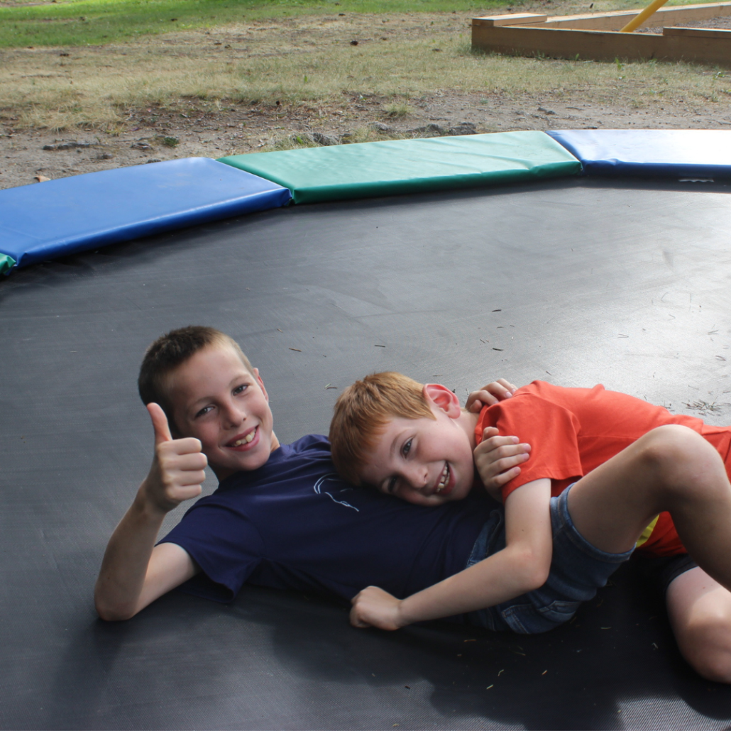 two boys playing on a trampoline